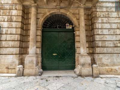 Un portale monumentale, con due possenti colonne tuscaniche, chiude il massiccio portone di ingresso